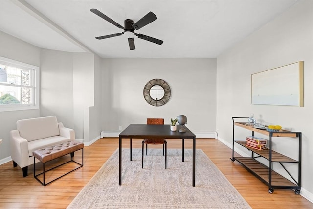 office area featuring a baseboard heating unit, hardwood / wood-style floors, and ceiling fan