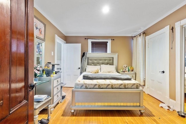 bedroom with light wood-type flooring and crown molding