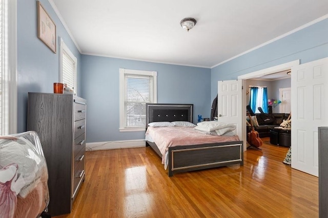 bedroom featuring ornamental molding and light wood-type flooring