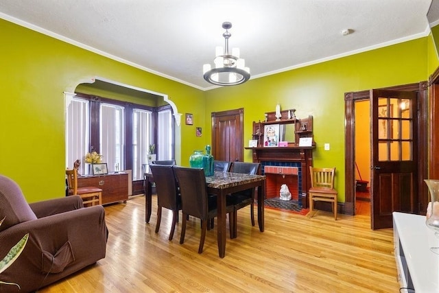 dining space with a chandelier, crown molding, and light hardwood / wood-style flooring