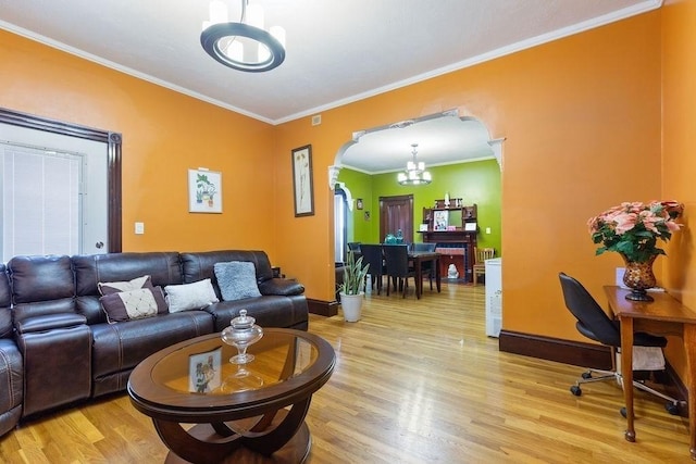 living room with ornamental molding, light hardwood / wood-style flooring, and a chandelier