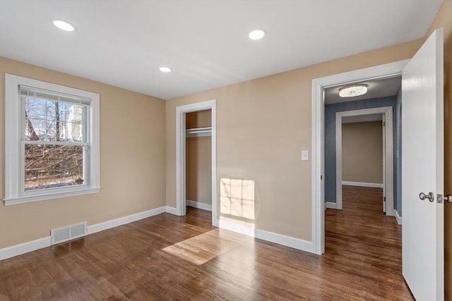 unfurnished bedroom with wood-type flooring and a closet