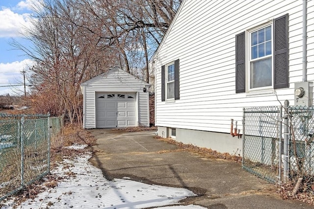 view of snow covered exterior featuring a garage and an outdoor structure