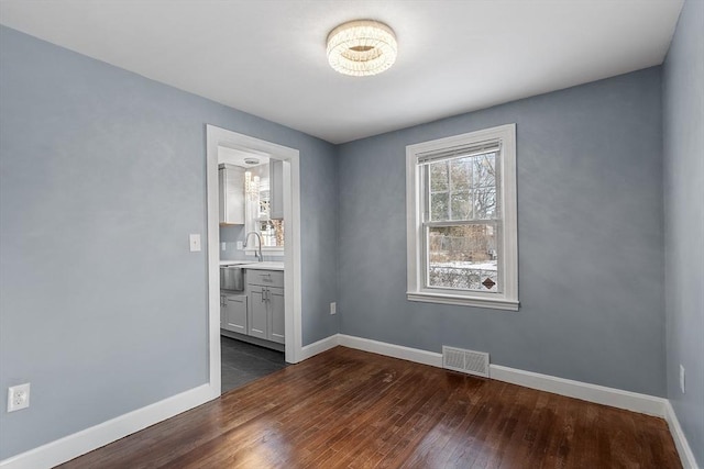 unfurnished room with sink and dark wood-type flooring