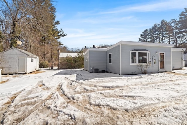 view of snowy exterior with a storage shed and an outdoor structure