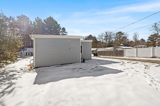 snow covered structure featuring fence