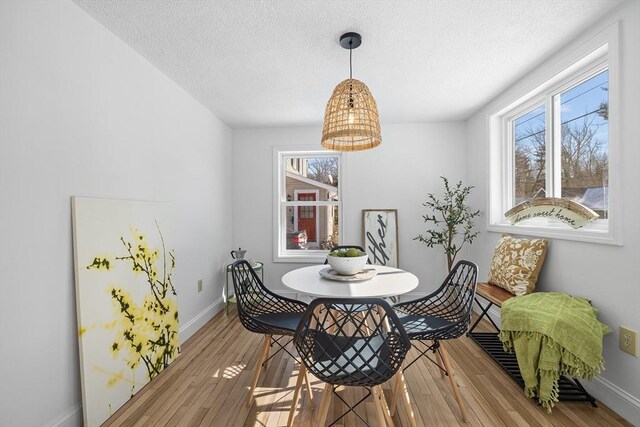 dining area featuring a healthy amount of sunlight, baseboards, and hardwood / wood-style flooring