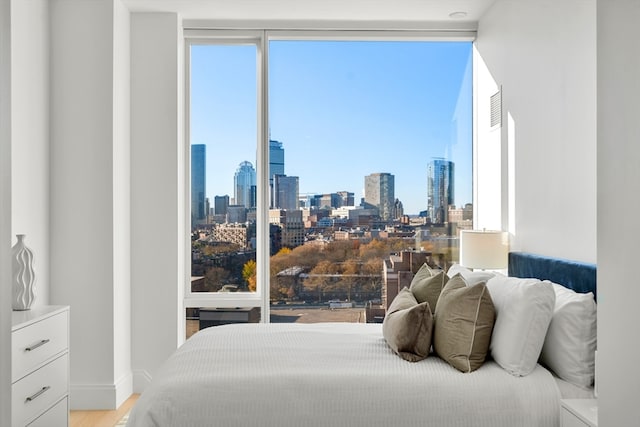 bedroom with hardwood / wood-style flooring and multiple windows