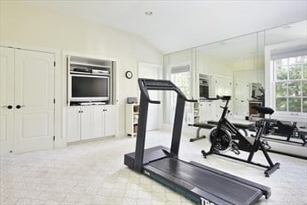 workout room with light carpet and lofted ceiling