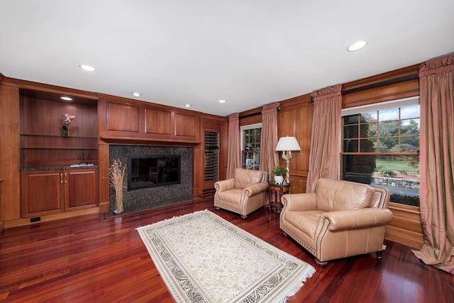 living room featuring dark hardwood / wood-style flooring, a fireplace, and built in shelves