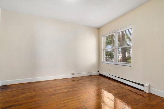 25-29 Astoria St, Boston, MA 02126 - empty room featuring wood finished floors, a baseboard heating unit, and baseboards