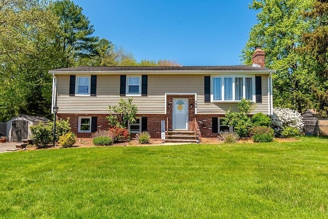 bi-level home featuring a chimney, a front yard, a shed, and entry steps