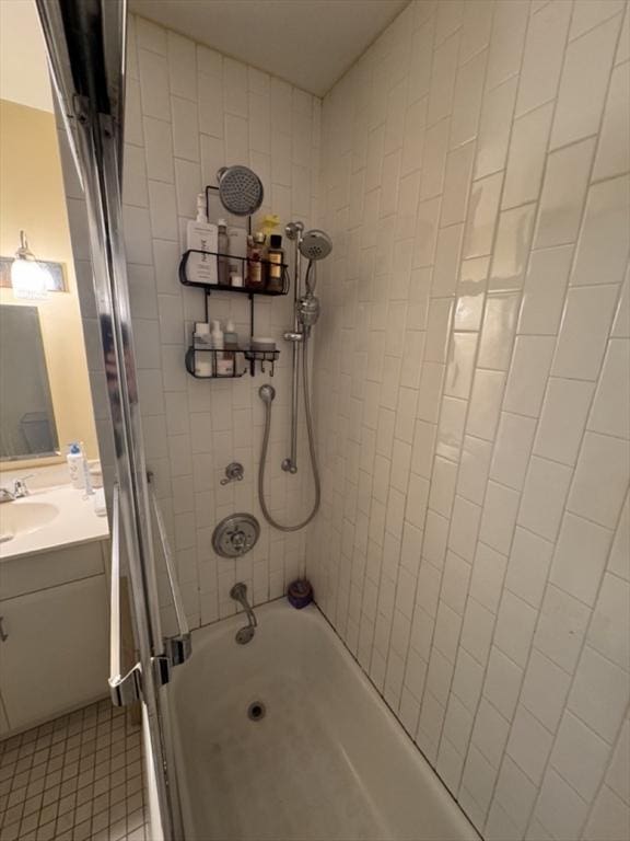 bathroom featuring vanity and tiled shower / bath