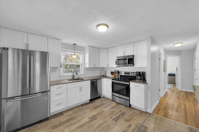1 Walter St, Worcester, MA 01609 - kitchen featuring appliances with stainless steel finishes, light stone countertops, white cabinetry, and a textured ceiling