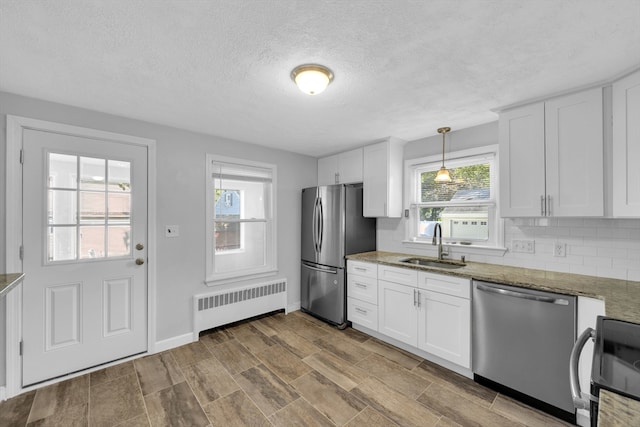 1 Walter St, Worcester, MA 01609 - kitchen with radiator heating unit, appliances with stainless steel finishes, light stone countertops, white cabinets, and a textured ceiling