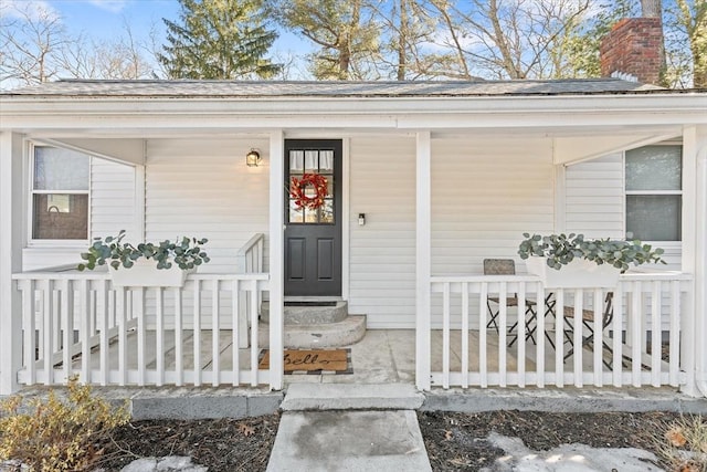 property entrance with covered porch and a chimney