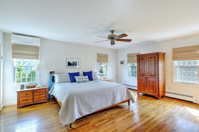 47 Fallon Dr, Westport, MA 02790 - bedroom featuring an AC wall unit, a baseboard radiator, light wood-style floors, and a ceiling fan