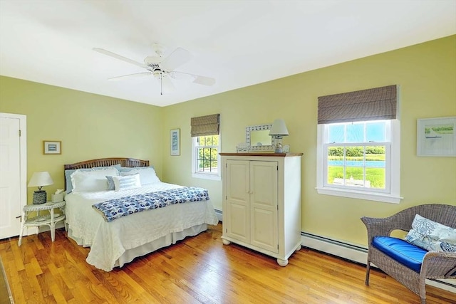 47 Fallon Dr, Westport, MA 02790 - bedroom with a baseboard heating unit, light wood-type flooring, and ceiling fan