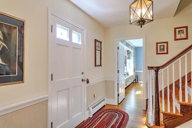 47 Fallon Dr, Westport, MA 02790 - foyer entrance with baseboard heating, stairway, light wood-type flooring, and a chandelier