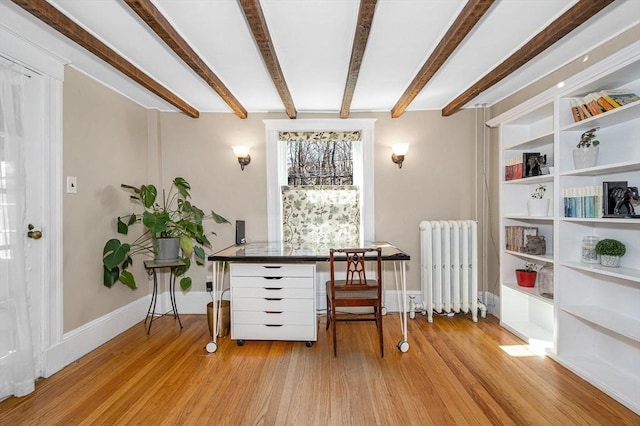 living area with beamed ceiling, light wood-type flooring, radiator heating unit, and baseboards