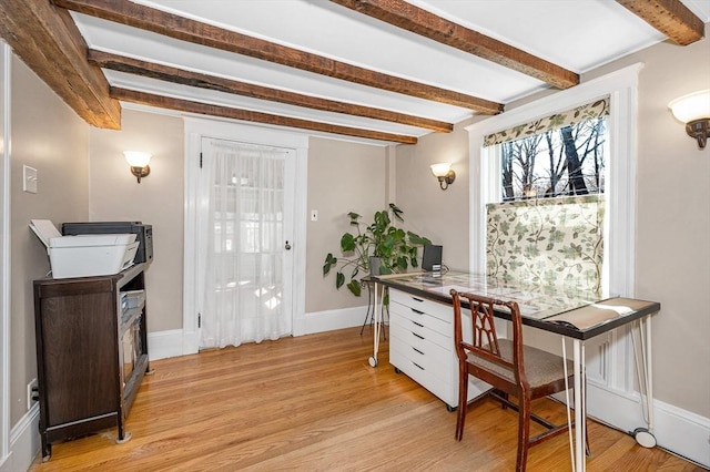 office space with beamed ceiling, baseboards, and light wood-style floors