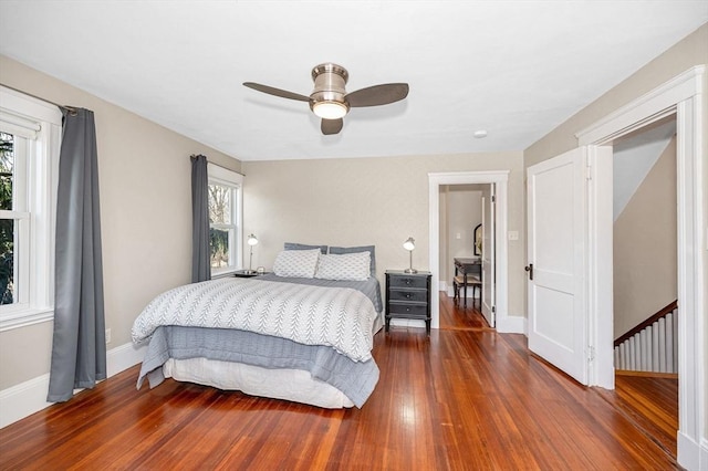 bedroom featuring ceiling fan, baseboards, and wood-type flooring