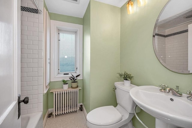 bathroom with toilet, a sink, radiator heating unit, tile patterned flooring, and baseboards