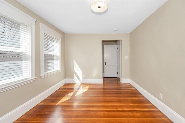 empty room with wood finished floors and baseboards