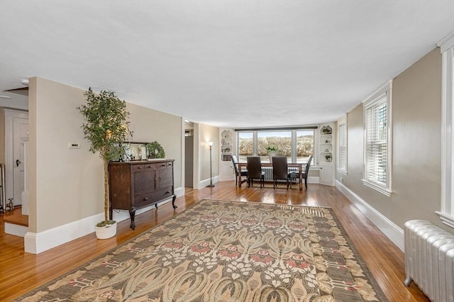 dining room featuring baseboards, wood finished floors, and radiator heating unit