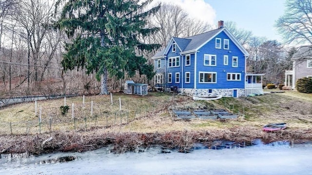 back of property featuring a garden and a chimney