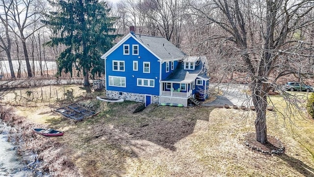 back of property with a chimney and a shingled roof