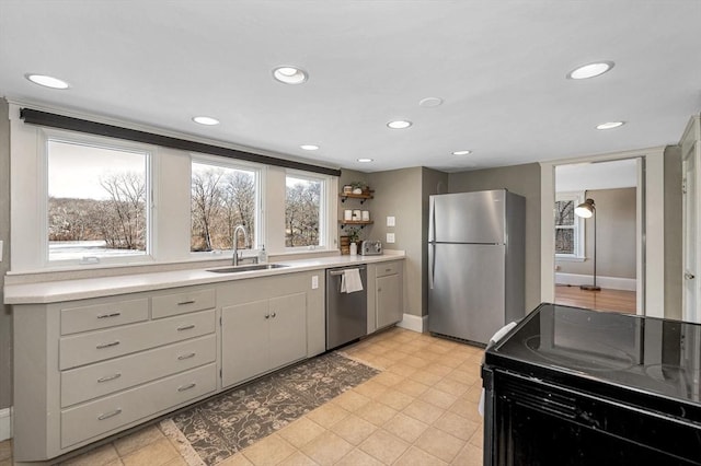 kitchen with recessed lighting, appliances with stainless steel finishes, light countertops, and a sink