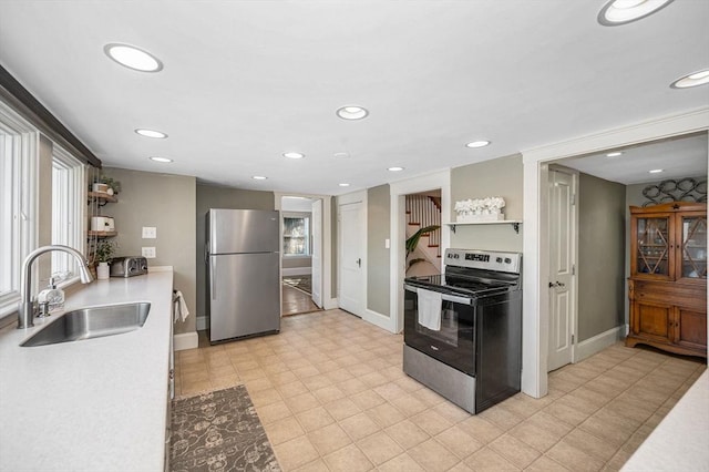 kitchen featuring a sink, light countertops, recessed lighting, and stainless steel appliances