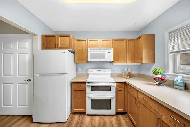 43 Kendall Ave Unit G03, Sherborn, MA 01770 - kitchen featuring white appliances, light wood-style flooring, light countertops, and brown cabinetry