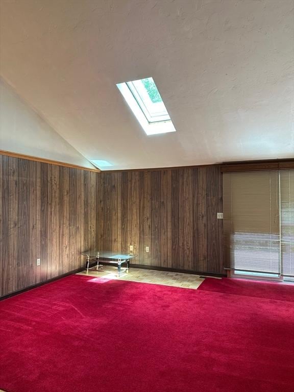 211 Stevens St, Marlborough, MA 01752 - additional living space with lofted ceiling, a skylight, carpet flooring, and wooden walls