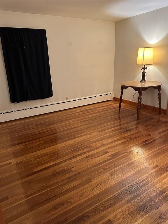 211 Stevens St, Marlborough, MA 01752 - spare room with a baseboard radiator, dark wood-type flooring, and baseboards
