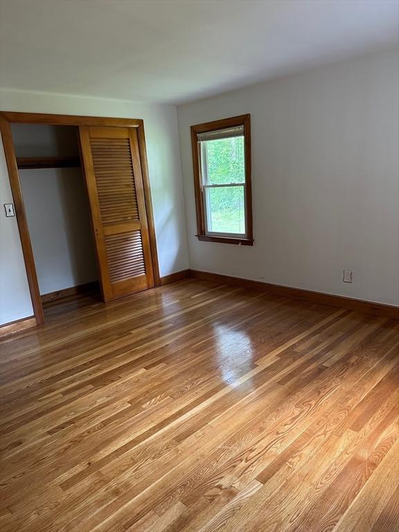 211 Stevens St, Marlborough, MA 01752 - unfurnished bedroom with a closet, light wood finished floors, and baseboards