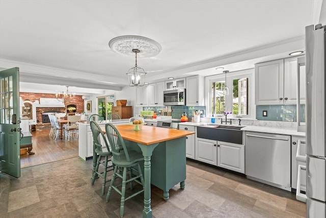 7 Stoney Hill Rd, Mattapoisett, MA 02739 - kitchen with stainless steel appliances, wood counters, a chandelier, backsplash, and a breakfast bar area