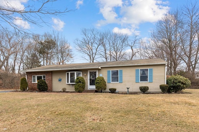 ranch-style home with a front yard and brick siding