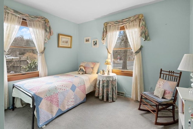 carpeted bedroom featuring visible vents