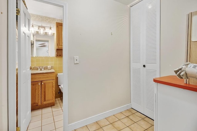 hallway with light tile patterned flooring and baseboards