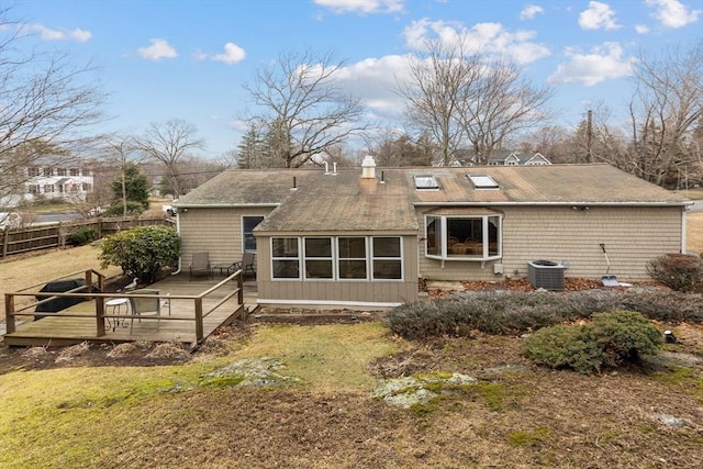 back of house with a chimney, central air condition unit, a wooden deck, and fence