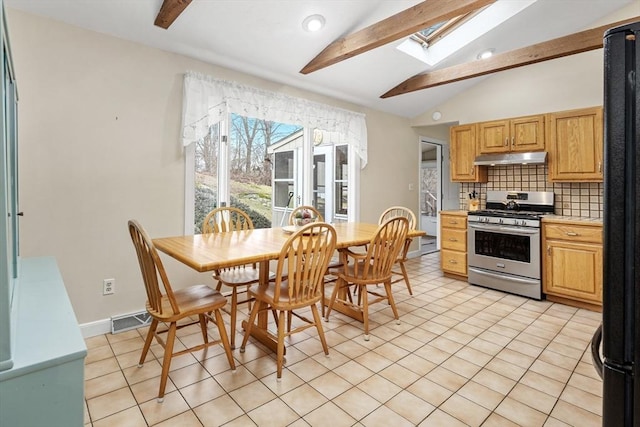 kitchen with visible vents, under cabinet range hood, backsplash, vaulted ceiling with skylight, and stainless steel gas range