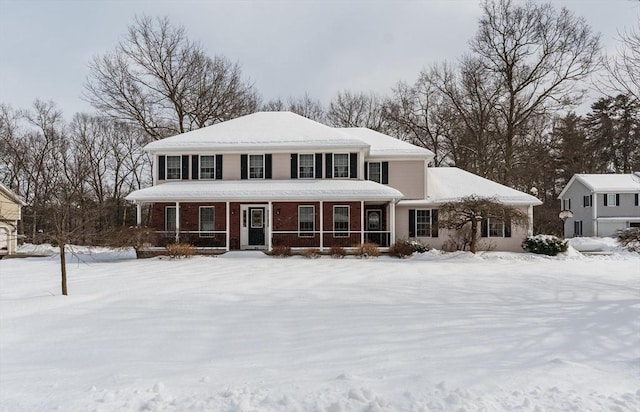 view of front of property featuring brick siding and covered porch