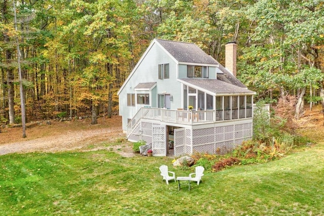 exterior space with stairs, a lawn, a sunroom, and a chimney