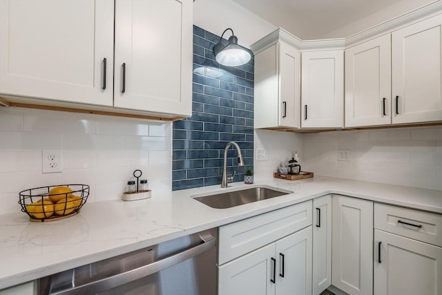 kitchen with sink, stainless steel dishwasher, white cabinets, light stone countertops, and backsplash