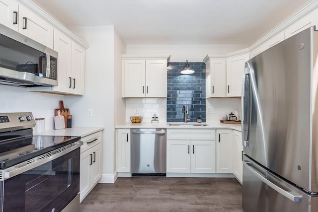 kitchen with stainless steel appliances, dark hardwood / wood-style floors, sink, and white cabinets