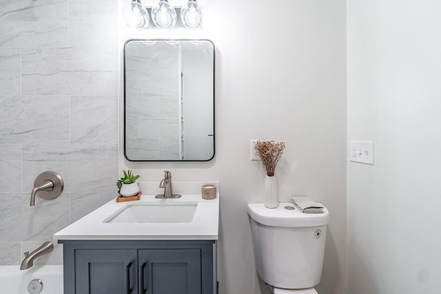 bathroom with vanity, toilet, and a bathing tub