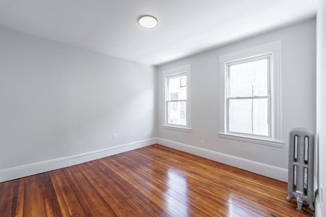 unfurnished room featuring hardwood / wood-style floors and radiator heating unit