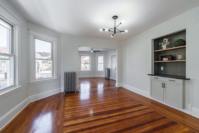 interior space featuring radiator, dark wood-type flooring, and a chandelier